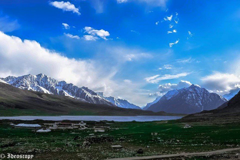 Scenic sunrise view of Shandur Lake in Shandur National Park with mountains reflecting on water