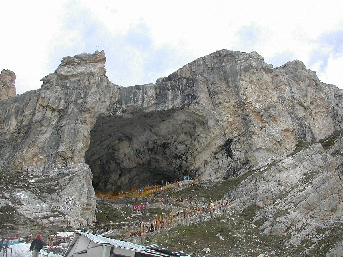 Sacred Amarnath Cave with natural ice stalagmite and devotees in Kashmir