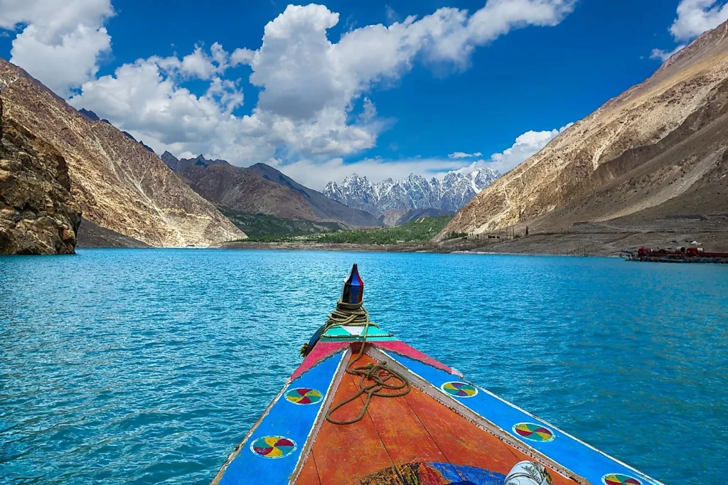 Tourists boating on turquoise Attabad Lake surrounded by rocky peaks.Gilgit Tourism
