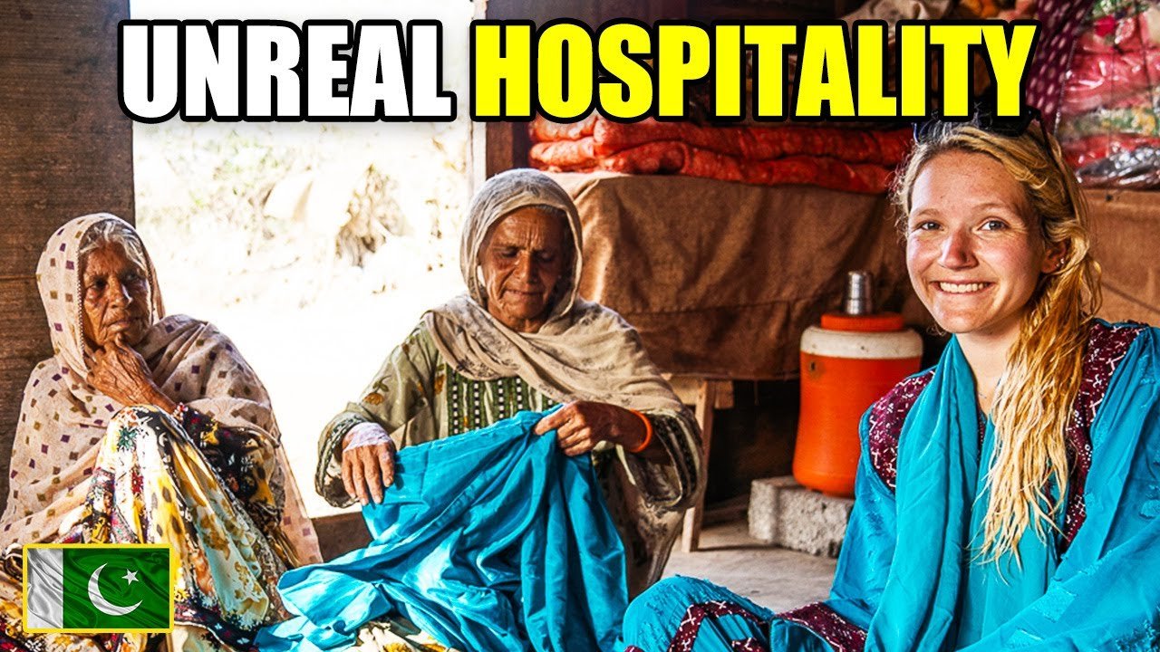 A smiling foreign traveler seated with elderly Pakistani women in traditional attire, reflecting the generosity and warmth of rural Pakistani hospitality