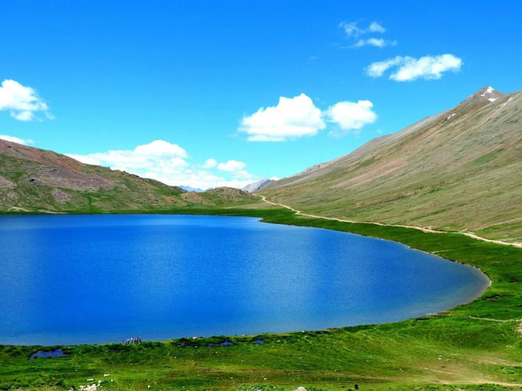 Clear water of Sheosar Lake with surrounding wildflowers in summer