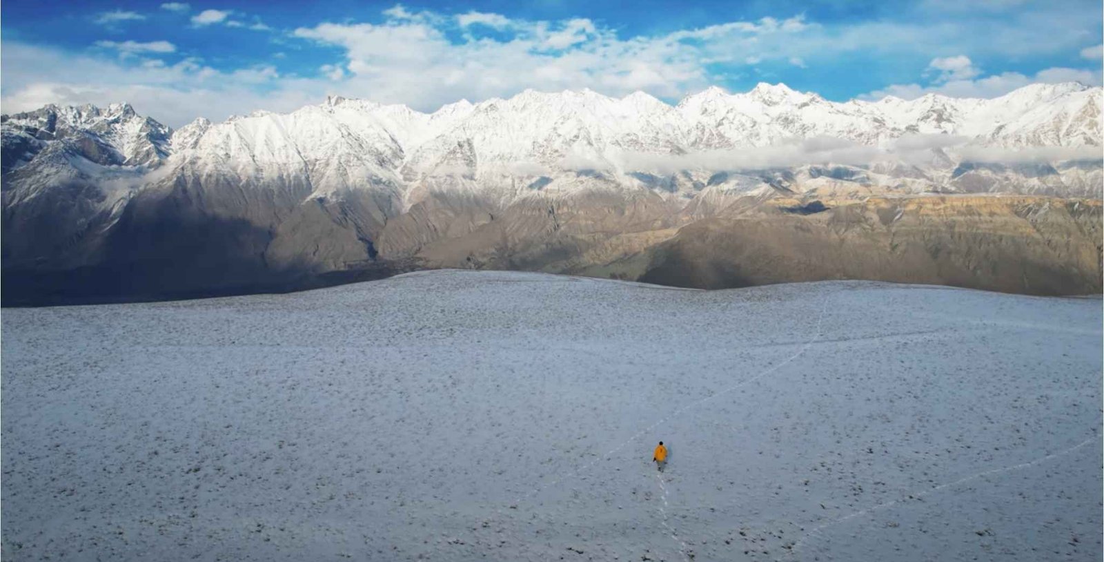 White sand dunes of Katpana Desert with tall mountains in the distance
